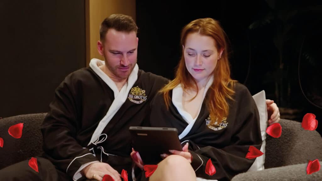 Couple in robes looking at tablet